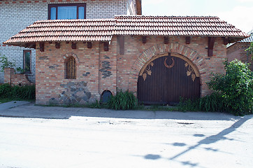 Image showing building of red brick and wooden gates