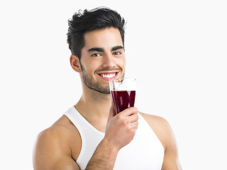 Image showing Athletic man drinking a juice