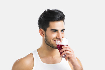 Image showing Athletic man drinking a juice