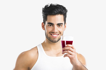 Image showing Athletic man drinking a juice