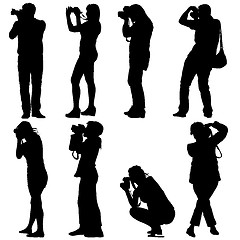 Image showing Cameraman with video camera. Silhouettes on white background. 