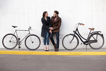 Image showing Young couple standing against the wall and hugging