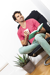 Image showing Man Sitting on Chair with Book and a Drink
