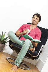 Image showing Man Sitting on Chair with Book and a Drink