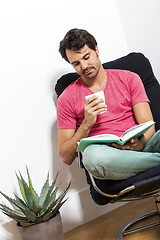 Image showing Man Sitting on Chair with Book and a Drink