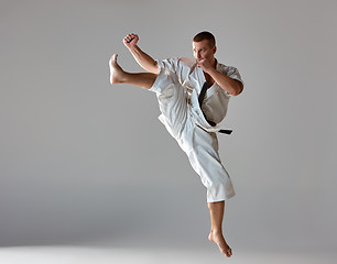 Image showing Man in white kimono training karate