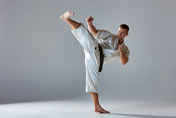 Image showing Man in white kimono training karate