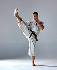 Image showing Man in white kimono training karate