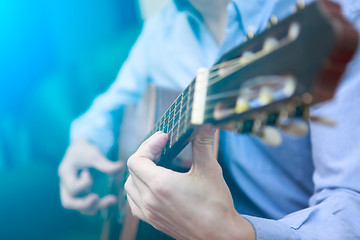 Image showing Young musician playing at acoustic guitar