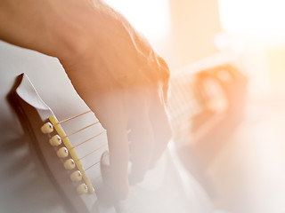 Image showing Male hand playing on acoustic guitar. Close-up.