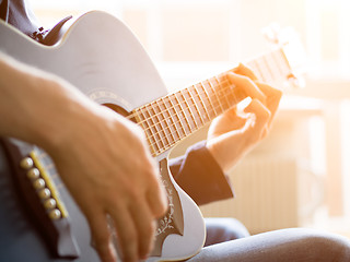 Image showing Male hand playing on acoustic guitar. Close-up.