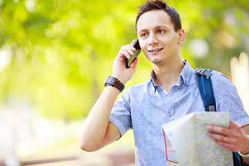 Image showing Man holding map outdoors and talking by phone