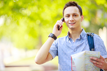 Image showing Man holding map outdoors and talking by phone