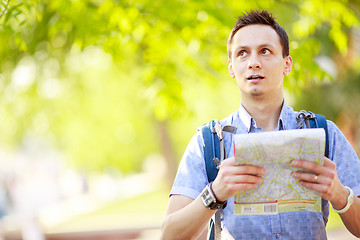 Image showing Young man with a map outdoors