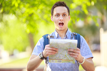 Image showing Young man with a map outdoors