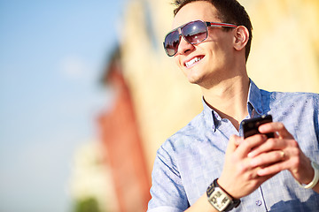 Image showing Outdoor portrait of man with mobile phone in the street.