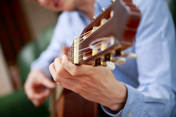 Image showing Young musician playing at acoustic guitar