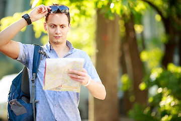 Image showing Young man with a map outdoors