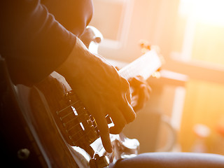 Image showing Male hand playing on acoustic guitar. Close-up.