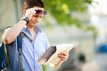 Image showing Young man with a map outdoors