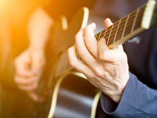 Image showing Male hand playing on acoustic guitar. Close-up.