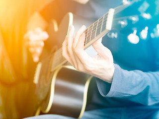 Image showing Male hand playing on acoustic guitar. Close-up.