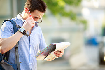 Image showing Young man with a map outdoors