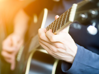 Image showing Male hand playing on acoustic guitar. Close-up.