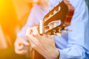 Image showing Young musician playing at acoustic guitar