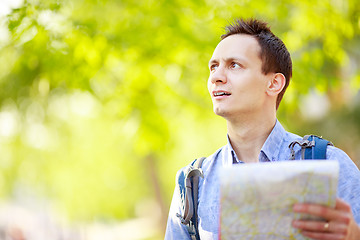 Image showing Young man with a map outdoors