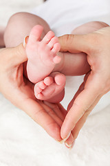 Image showing Mother holding newborns feet