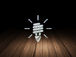 Image showing Finance concept: Energy Saving Lamp in grunge dark room