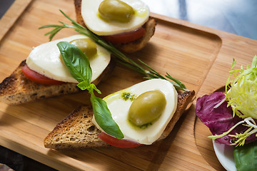 Image showing Bruschetta with tomato, mozarella and olive