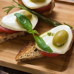 Image showing Bruschetta with tomato, mozarella and olive