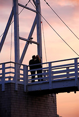 Image showing Couple kissing on a bridge