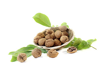 Image showing crunchy walnuts with walnut leaves in a basket