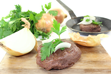 Image showing Ostrich steak with onions and parsley
