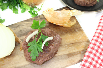 Image showing Ostrich steaks with sharp onions