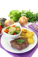 Image showing Ostrich steaks with baked potatoes and vegetables