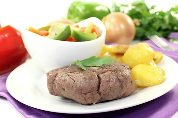 Image showing Ostrich steaks with baked potatoes and parsley