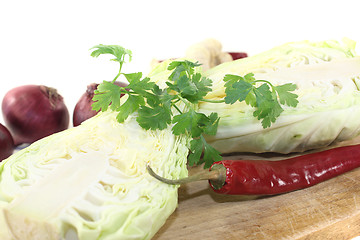Image showing sweetheart Cabbage with hot peppers on a board