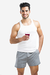 Image showing Athletic man drinking a juice