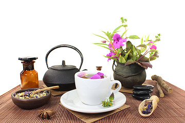 Image showing Chinese natural medicine with a cup of tea and blossoms