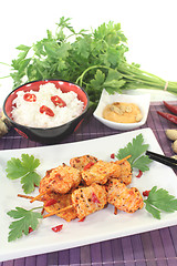Image showing Asian satay skewers with rice and parsley