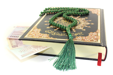 Image showing slammed Quran with Iranian currency