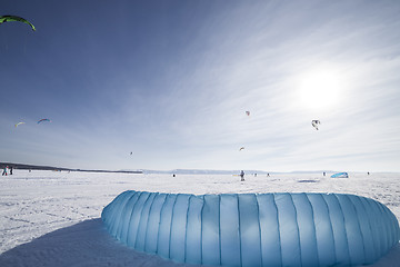 Image showing Kiteboarder with blue kite on the snow