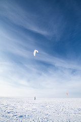 Image showing Kiteboarder with blue kite on the snow