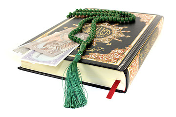 Image showing slammed Quran with Pakistani currency