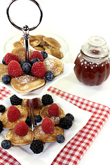 Image showing Poffertjes with berries and jelly on a cake stand