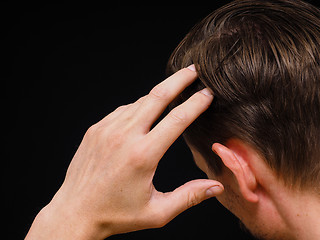 Image showing Closeup of a caucasian male thinking with one hand towards head 